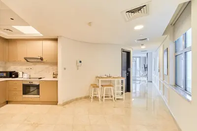 a kitchen with a table and chairs in a room at 1BR Sky Gardens Balcony with Stunning DIFC View in Dubai