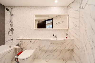 a bathroom with a sink and a toilet and a mirror at 1BR Sky Gardens Balcony with Stunning DIFC View in Dubai