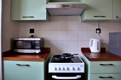 a kitchen with a stove and a microwave at Botanic Apartment 1BR, Pool, Tennis Court in Dubai