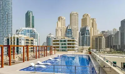 a balcony with a swimming pool and a city skyline at Botanic Apartment 1BR, Pool, Tennis Court in Dubai