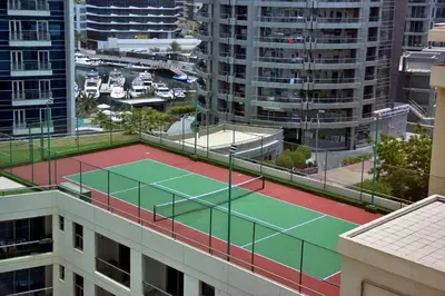 a tennis court on top of a building at Botanic Apartment 1BR, Pool, Tennis Court in Dubai