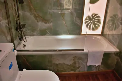 a bathroom with a bath tub and a toilet at Botanic Apartment 1BR, Pool, Tennis Court in Dubai
