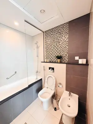 a bathroom with a toilet and a bath tub at Downtown Escape 2BR with Full BurjKhalifa Panorama in Dubai