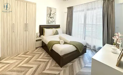 a bedroom with a bed and a large window at Downtown Living - Business Bay 1BR in Dubai