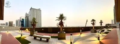 a row of benches and palm trees in a city at Downtown Living - Business Bay 1BR in Dubai