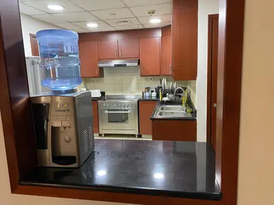 a small kitchen with a large clear container on the counter at Alsahel Vacation 1 in Dubai