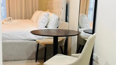 a room with a bed and a table and chairs at JBR Studio Apartment - Bay Central in Dubai