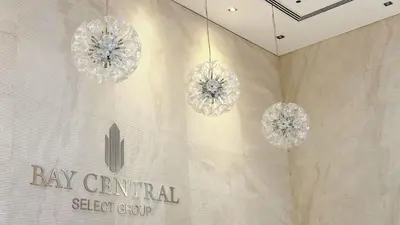 three chandeliers hanging from a wall with the bay central steel group at JBR Studio Apartment - Bay Central in Dubai