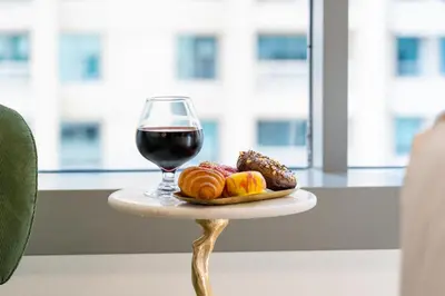 a glass of red wine and a plate of food at The Boulevard Suite Stunning Burj Khalifa View Downtown in Dubai