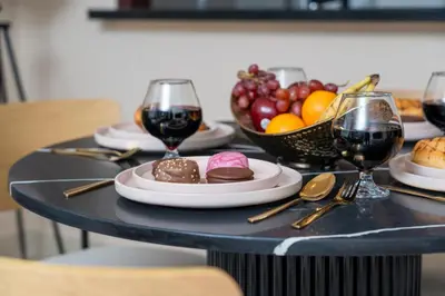 a table with plates of food and glasses of wine at The Boulevard Suite Stunning Burj Khalifa View Downtown in Dubai
