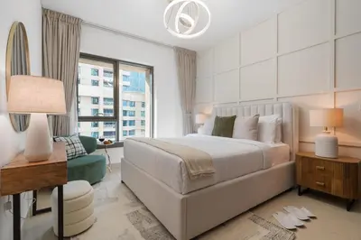 a white bedroom with a bed and a window at The Boulevard Suite Stunning Burj Khalifa View Downtown in Dubai