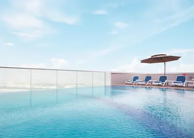 a swimming pool with chairs and an umbrella at Treppan Hotel & Suites By Fakhruddin in Dubai