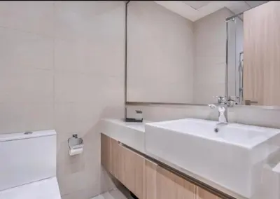 a white bathroom with a sink and a mirror at Cosy studio in Dubai