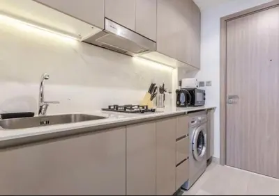 a kitchen with a sink and a washing machine at Cosy studio in Dubai