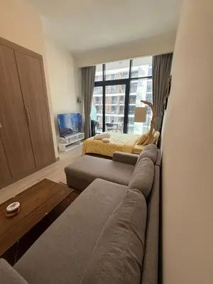 a bedroom with a bed and a couch and a window at Cosy studio in Dubai