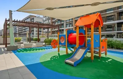 an outdoor playground with a slide and an umbrella at Azizi Riviera , Meydan, Dubai Burj Khalifa view in Dubai