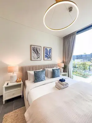 two beds in a bedroom with a window at Luxury 1BR, The Crest, Sobha Hartland in Dubai