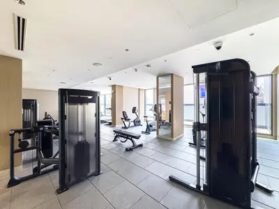 a gym with tread machines and mirrors in a building at Luxury 1BR, The Crest, Sobha Hartland in Dubai