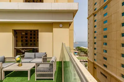 a balcony with a table and chairs on a building at Shams, JBR - 2BR Apartment - Allsopp & Allsopp in Dubai