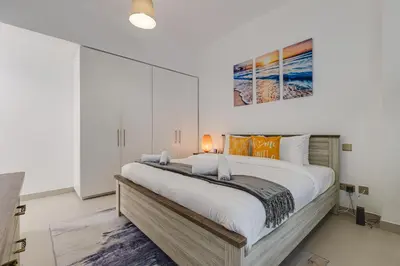 a bedroom with a large bed and a painting on the wall at Shams, JBR - 2BR Apartment - Allsopp & Allsopp in Dubai