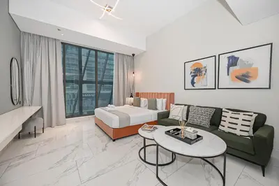 a living room with a bed and a couch and a table at Modern Comfort with Pool and Free Parking Near Dubai Fountain and Burj Khalifa in Dubai