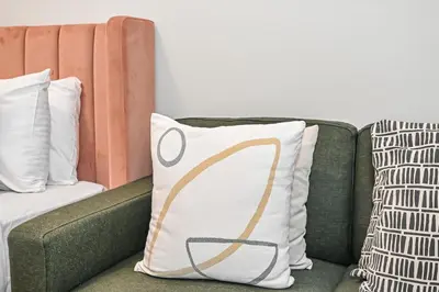 a green couch with a pillow with a design on it at Modern Comfort with Pool and Free Parking Near Dubai Fountain and Burj Khalifa in Dubai