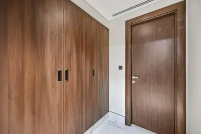 a closet with wooden doors in a room at Modern Comfort with Pool and Free Parking Near Dubai Fountain and Burj Khalifa in Dubai