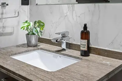 a bottle of wine sitting on a bathroom sink at Modern Comfort with Pool and Free Parking Near Dubai Fountain and Burj Khalifa in Dubai