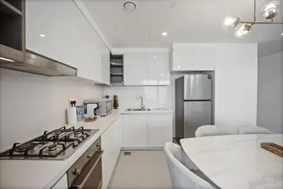 a kitchen with white cabinets and a stove top oven at Experience the Downtown Views Perfect 2BR wt Balco in Dubai