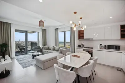a kitchen and living room with a couch and a table at Experience the Downtown Views Perfect 2BR wt Balco in Dubai