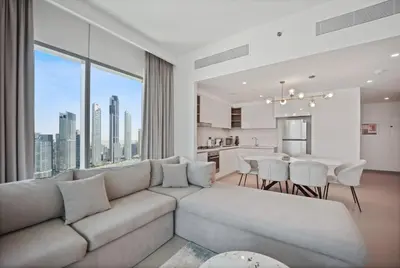 a living room with a couch and a kitchen at Experience the Downtown Views Perfect 2BR wt Balco in Dubai