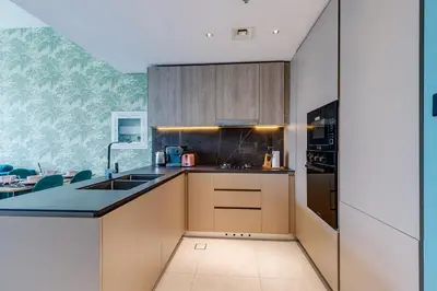 a kitchen with wooden cabinets and a black counter top at Oxford Boulevard - 1 BR Apartment - Allsopp & Allsopp in Dubai