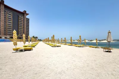 a beach with lounge chairs and umbrellas and the ocean at Stunning Sea View 3BR with Private Beach in Dubai