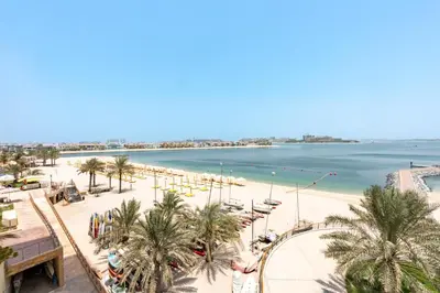 a view of a beach with palm trees and the ocean at Stunning Sea View 3BR with Private Beach in Dubai