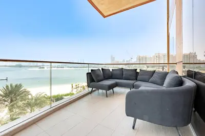 a living room with a couch and a view of the beach at Stunning Sea View 3BR with Private Beach in Dubai