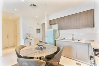 a kitchen with a wooden table and chairs at Bright 1BR APT in Dubai Hills Near Burj Khalifa in Dubai
