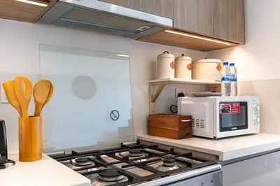 a kitchen with a stove and a microwave at Bright 1BR APT in Dubai Hills Near Burj Khalifa in Dubai