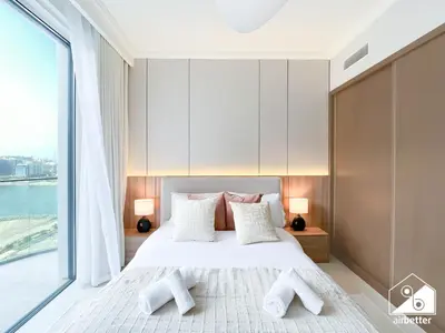 a bedroom with a bed and a large window at Elegant 1B by the Beach & iconic Views in Dubai
