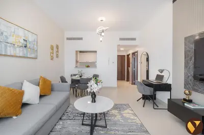a living room with a couch and a table at Vogue JVC Jeewar Tower near Circle Mall, One Bedroom Apartment with Balcony and City View, Access to all Amenities in Dubai
