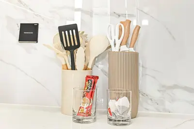 a counter with two glasses and a container with utensils at Golden Stays - Binghatti Tulip I Chic 1BR Apartment I Balcony Views I JVC Dubai in Dubai