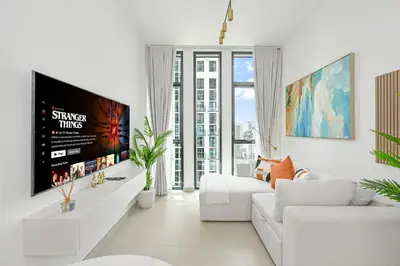 a living room with a white couch and a tv at Golden Stays - Binghatti Tulip I Chic 1BR Apartment I Balcony Views I JVC Dubai in Dubai