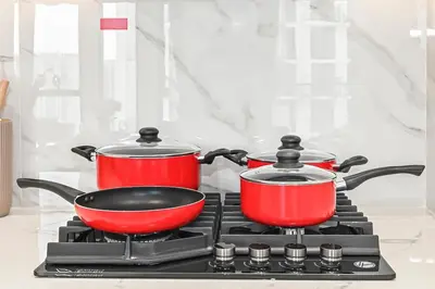 two pots and a pan on a stove at Golden Stays - Binghatti Tulip I Chic 1BR Apartment I Balcony Views I JVC Dubai in Dubai