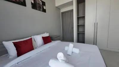 a bedroom with a white bed with red and white pillows at High Floor 2 Bedroom in V Tower in Dubai