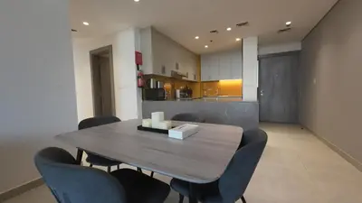 a dining room with a wooden table and chairs at High Floor 2 Bedroom in V Tower in Dubai