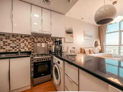 a kitchen with a sink and a stove top oven at Cozy Studio Themed Designed In JVT in Dubai