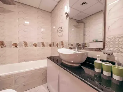 a bathroom with a sink and a bath tub and a sink at Cozy Studio Themed Designed In JVT in Dubai
