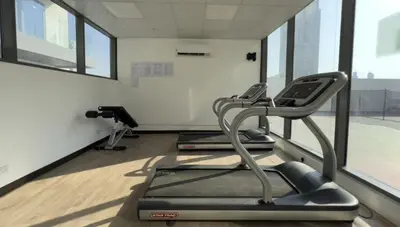 a gym with two exercise bikes and a treadmill at Cozy Studio in JVC in Dubai