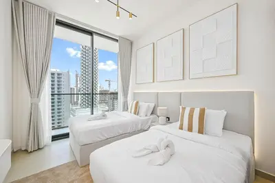 two beds in a room with a large window at Golden Stays - Private Pool in Binghatti Tulip I Prime JVC 2BR I Balcony Access in Dubai
