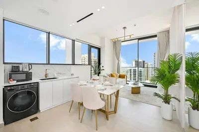 a kitchen and living room with a table and chairs at Golden Stays - Private Pool in Binghatti Tulip I Prime JVC 2BR I Balcony Access in Dubai