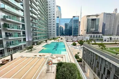 a pool in the middle of a city with tall buildings at Stunning Burj Views Studio Mins to Dubai Mall 603 in Dubai